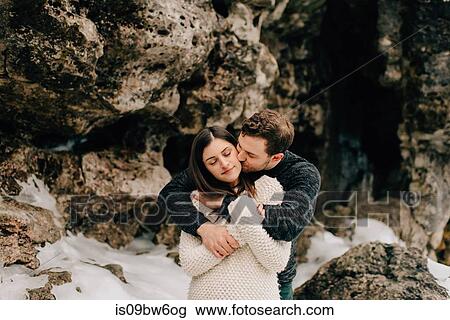 Stock Image - Couple hugging beside rock face, Tobermory, Canada. Fotosearch