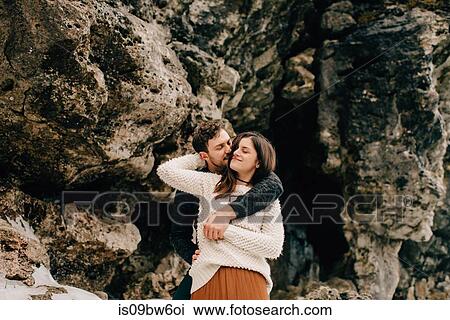 Stock Image - Couple hugging beside rock face, Tobermory, Canada. Fotosearch