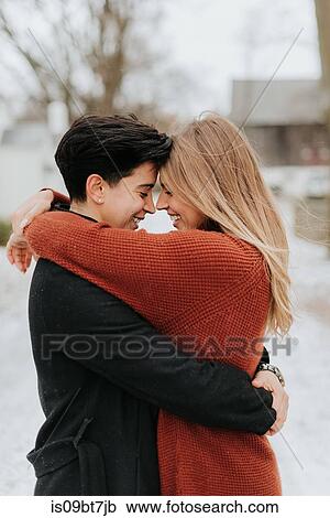 Stock Image - Couple hugging in snowy landscape, Georgetown, Canada. Fotosearch