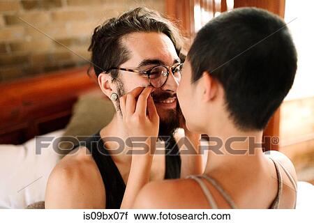 Stock Image - Couple hugging sitting on bed. Fotosearch