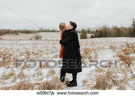 Stock Image - Couple kissing in snow, Georgetown, Canada. Fotosearch