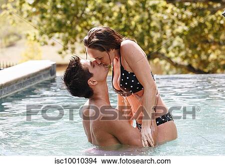 Couple kissing in swimming pool View Large Photo Image Picture - Couple kissing in swimming pool. Fotosearch
