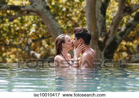 Couple kissing in swimming pool View Large Photo Image Stock Photo - Couple kissing in swimming pool. Fotosearch