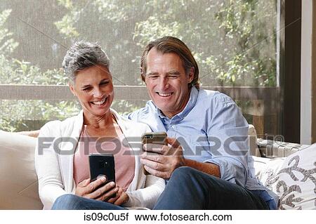 Couple laughing at cellphone messages View Large Photo Image Stock Image - Couple laughing at cellphone messages. Fotosearch