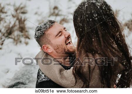 Couple laughing in snowy landscape View Large Photo Image Stock Image - Couple laughing in snowy landscape. Fotosearch