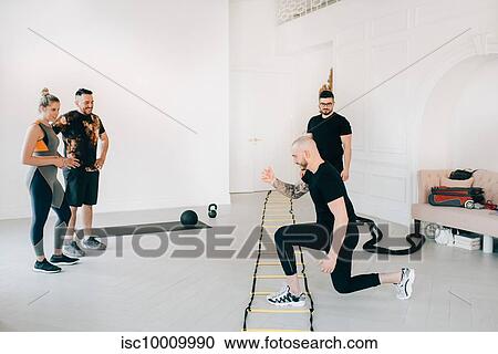 Couple observing fitness instructor using agility ladder in studio View Large Photo Image Stock Image - Couple observing fitness instructor using agility ladder in studio. Fotosearch