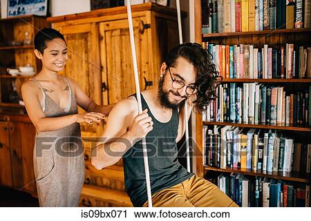 Stock Image - Couple on indoor swing. Fotosearch
