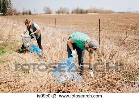 Couple picking up rubbish by field, Georgetown, Canada View Large Photo Image Stock Image - Couple picking up rubbish by field, Georgetown, Canada. Fotosearch