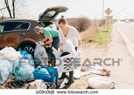 Stock Photo - Couple picking up rubbish by roadside, Georgetown, Canada. Fotosearch