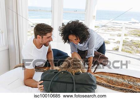 Couple playing with daughter on bed in beach house View Large Photo Image Stock Photography - Couple playing with daughter on bed in beach house. Fotosearch