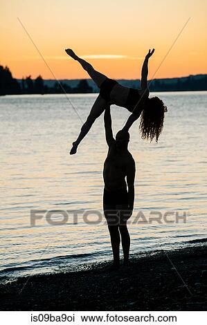 Couple practising yoga on beach at sunset View Large Photo Image Stock Image - Couple practising yoga on beach at sunset. Fotosearch