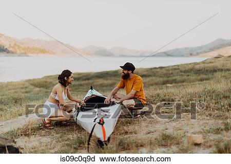 Stock Image - Couple preparing kayak by lake, Kaweah, California, United States. Fotosearch