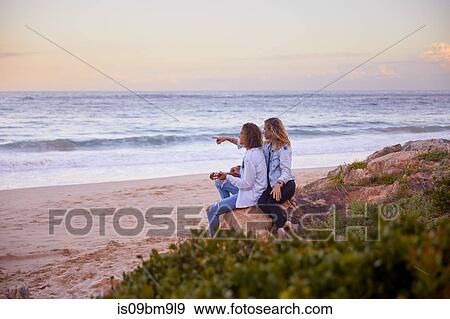 Stock Photo - Couple relaxing on beach, Plettenberg Bay, Western Cape, South Africa. Fotosearch