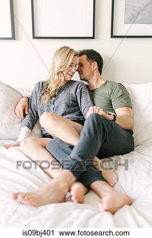 Couple relaxing on bed, legs entwined View Large Photo Image Stock Image - Couple relaxing on bed, legs entwined. Fotosearch
