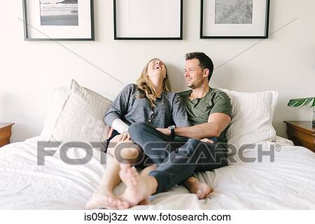 Couple relaxing on bed, legs entwined View Large Photo Image Stock Photo - Couple relaxing on bed, legs entwined. Fotosearch