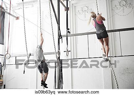 Couple rope climbing in cross training gym View Large Photo Image Stock Photography - Couple rope climbing in cross training gym. Fotosearch