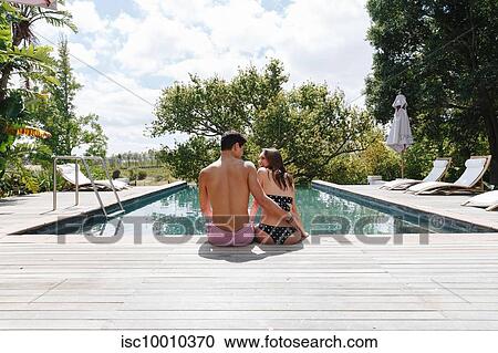 Couple sitting by swimming pool View Large Photo Image Stock Image - Couple sitting by swimming pool. Fotosearch