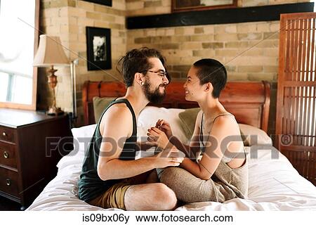 Couple sitting cross legged on bed View Large Photo Image Stock Photo - Couple sitting cross legged on bed. Fotosearch