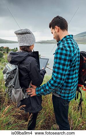 Couple standing beside Dillon Reservoir, using digital tablet, Silverthorne, Colorado, USA View Large Photo Image Picture - Couple standing beside Dillon Reservoir, using digital tablet, Silverthorne, Colorado, USA. Fotosearch