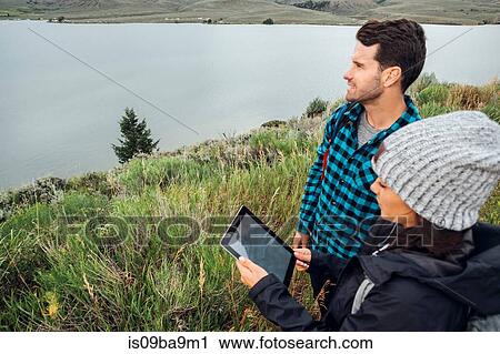 Couple standing beside Dillon Reservoir, using digital tablet, Silverthorne, Colorado, USA View Large Photo Image Stock Image - Couple standing beside Dillon Reservoir, using digital tablet, Silverthorne, Colorado, USA. Fotosearch