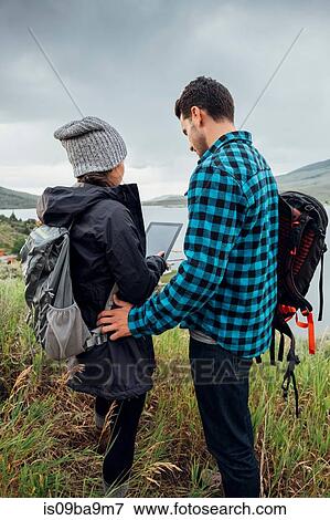 Stock Photo - Couple standing beside Dillon Reservoir, using digital tablet, Silverthorne, Colorado, USA. Fotosearch