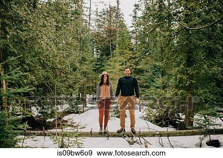 Couple standing on fallen tree trunk in forest, Tobermory, Canada View Large Photo Image Stock Photo - Couple standing on fallen tree trunk in forest, Tobermory, Canada. Fotosearch