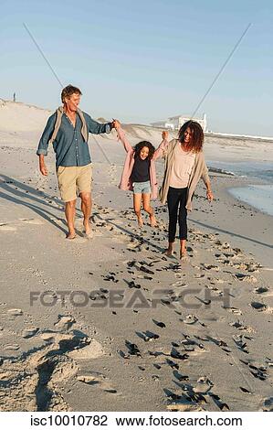 Couple swinging daughter in mid air on sandy beach View Large Photo Image Stock Image - Couple swinging daughter in mid air on sandy beach. Fotosearch
