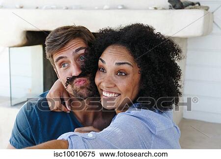 Stock Photography - Couple taking selfie in beach house. Fotosearch