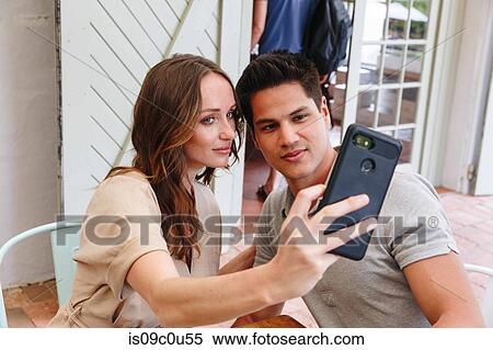 Stock Photography - Couple taking selfie in restaurant, Cape Town, South Africa. Fotosearch