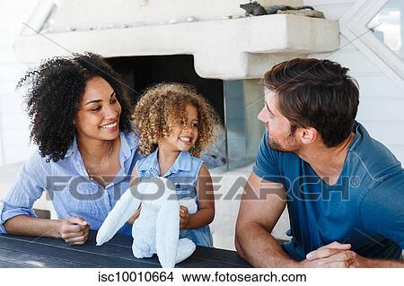 Couple talking and playing with daughter in beach house View Large Photo Image Picture - Couple talking and playing with daughter in beach house. Fotosearch