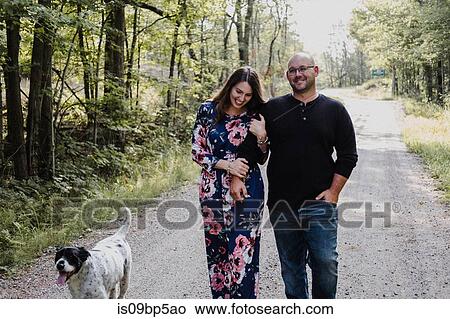 Picture - Couple walking with dog on countryside road. Fotosearch
