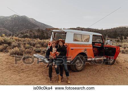 Picture - Couple with baby girl by offroad vehicle, Kennedy Meadows, California, US. Fotosearch