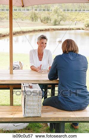 Stock Photo - Couple with picnic basket relaxing by pond, Cape Town, South Africa. Fotosearch