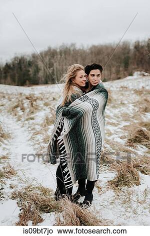 Picture - Couple wrapped in blanket in snowy landscape, Georgetown, Canada. Fotosearch