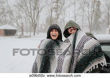 Stock Photo - Couple wrapped in blanket in snowy landscape, Georgetown, Canada. Fotosearch