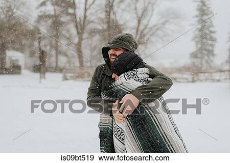 Couple wrapped in blanket in snowy landscape, Georgetown, Canada View Large Photo Image Stock Photo - Couple wrapped in blanket in snowy landscape, Georgetown, Canada. Fotosearch