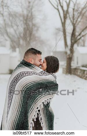Couple wrapped in blanket kissing in snowy landscape, Georgetown, Canada View Large Photo Image Stock Photo - Couple wrapped in blanket kissing in snowy landscape, Georgetown, Canada. Fotosearch