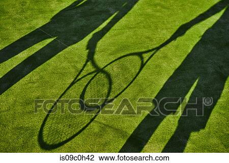 Cropped shadows of two tennis players with tennis rackets on green lawn View Large Photo Image Stock Image - Cropped shadows of two tennis players with tennis rackets on green lawn. Fotosearch