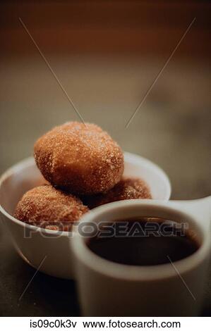 Cup of black coffee and bowl of doughnuts on cafe table, close up shallow focus View Large Photo Image Stock Photo - Cup of black coffee and bowl of doughnuts on cafe table, close up shallow focus. Fotosearch