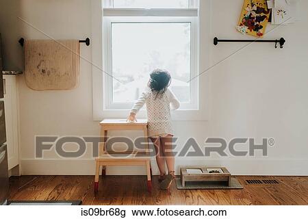 Curious girl looking out of window View Large Photo Image Stock Image - Curious girl looking out of window. Fotosearch