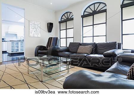 Dark brown leather love seat, sofa and reclining armchair, glass and aluminium coffee table in family room, beige rug and Palladian windows View Large Photo Image Stock Image - Dark brown leather love seat, sofa and reclining armchair, glass and aluminium coffee table in family room, beige rug and Palladian windows. Fotosearch