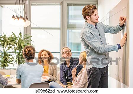 Stock Image - Digital design team discussing at conference table. Fotosearch