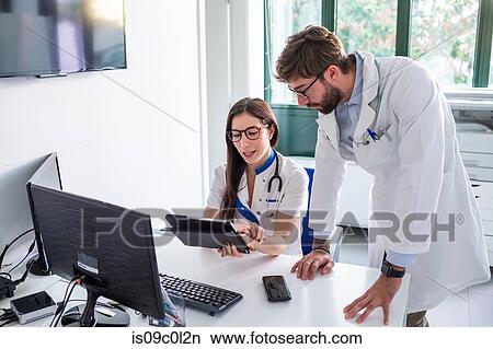 Picture - Doctor and nurse using digital tablet in hospital. Fotosearch