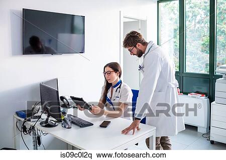 Stock Photography - Doctor and nurse using digital tablet in hospital. Fotosearch