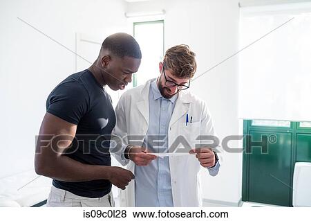 Doctor and patient reading medical results in hospital View Large Photo Image Stock Photo - Doctor and patient reading medical results in hospital. Fotosearch