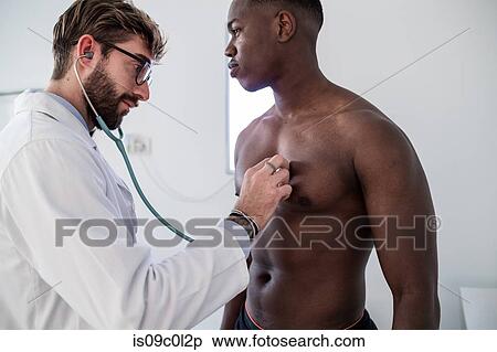 Stock Photography - Doctor examining patient in consultation room. Fotosearch