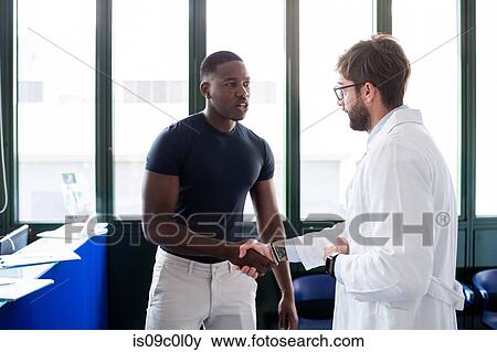Doctor speaking with patient at hospital reception View Large Photo Image Stock Photo - Doctor speaking with patient at hospital reception. Fotosearch