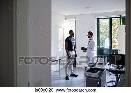 Doctor speaking with patient in consultation room View Large Photo Image Stock Image - Doctor speaking with patient in consultation room. Fotosearch