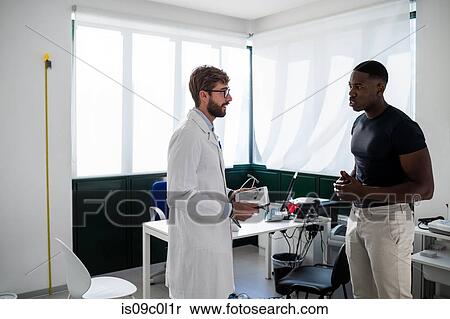 Doctor speaking with patient in consultation room View Large Photo Image Stock Photography - Doctor speaking with patient in consultation room. Fotosearch
