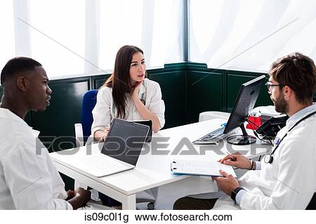 Stock Image - Doctors having discussion in meeting room. Fotosearch